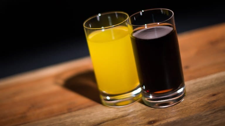 Ein Glas mit Cola steht neben einem Glas mit Orangenlimonade (Foto: picture-alliance / Reportdienste, Lukas Schulze)
