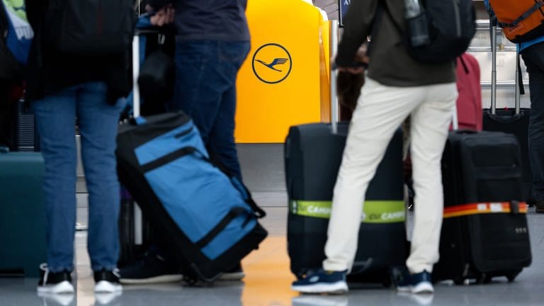 Passagiere warten am Flughafen an einem Check-In-Schalter der Lufthansa.  (Foto: dpa Bildfunk, picture alliance/dpa | Sven Hoppe)