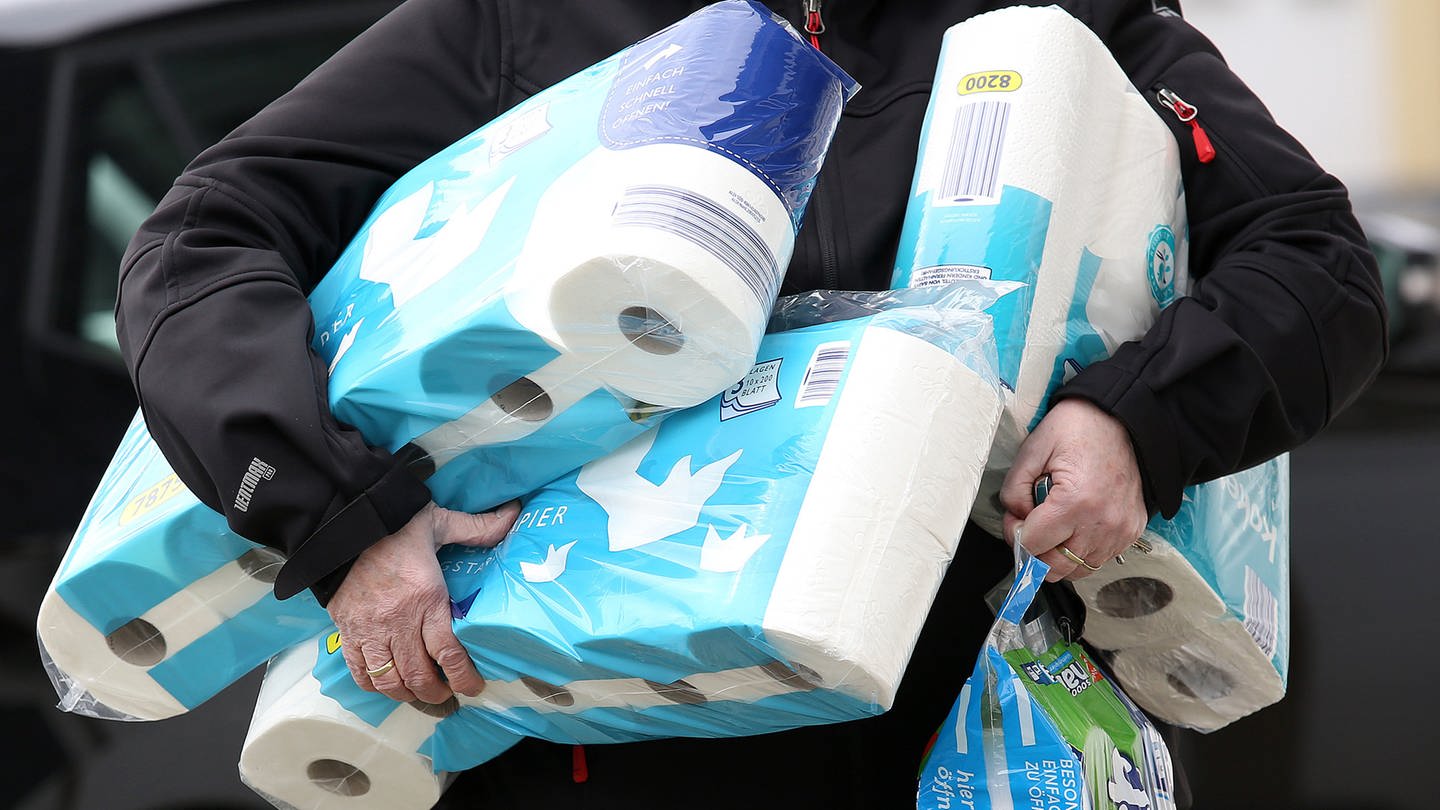 Ein Mann trägt mehrere Packungen Klopapier während der Corona-Pandemie. (Foto: picture-alliance / Reportdienste, Picture Alliance)
