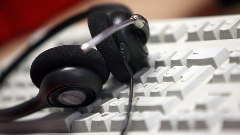 Headset auf Tastatur (Foto: dpa Bildfunk, picture alliance / Oliver Berg/dpa)