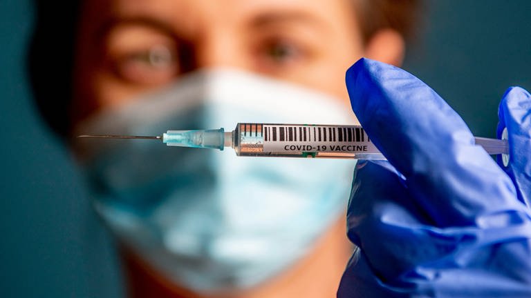 Eine Ärztin hält eine Spritze mit dem Corona-Impfstoff in der Hand