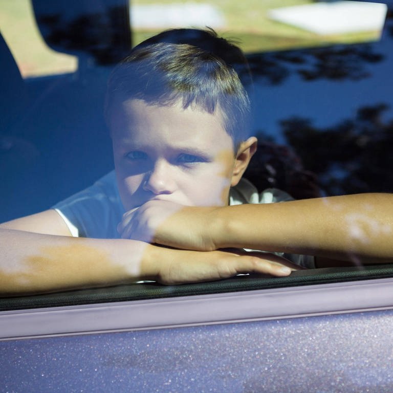 Ein kleiner Junge sitzt im Auto hinter einer geschlossenen Scheibe. (Foto: IMAGO, IMAGO / Panthermedia)