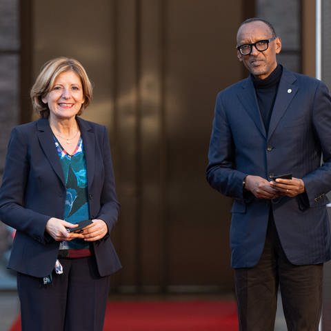 Die rheinland-pfälzische Ministerpräsidentin Malu Dreyer (SPD) und Paul Kagame, Präsident von Ruanda stehen vor einem Eingang und gucken Richtung Kamera