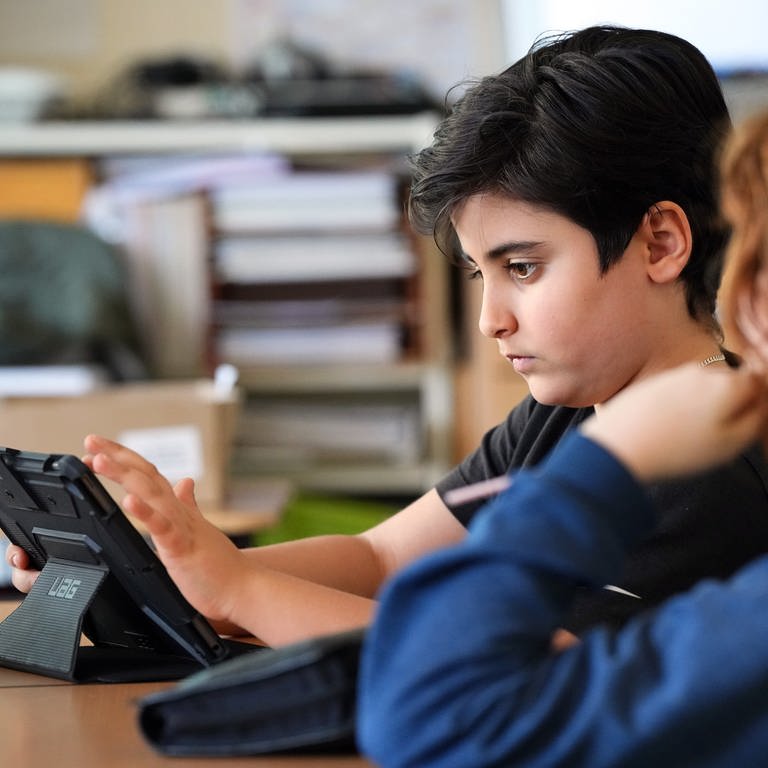 Ein Schüler arbeitet an einem Tablet.