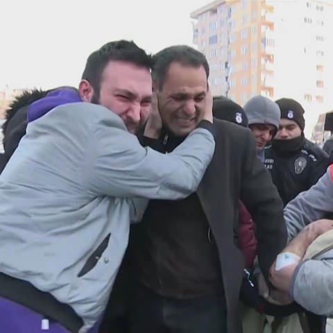 Zwei weinende Männer umarmen sich in der Türkei nach Erdbeben (Foto: SWR)