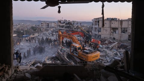 Bagger stehen in den Trümmern im Erdbebengebiet in der Türkei. Der Einsatz der schweren Geräte in solchen Gebieten sei sehr gefährlich, sagt ein THW-Experte. (Foto: dpa Bildfunk, picture alliance/dpa | Anas Alkharboutli)