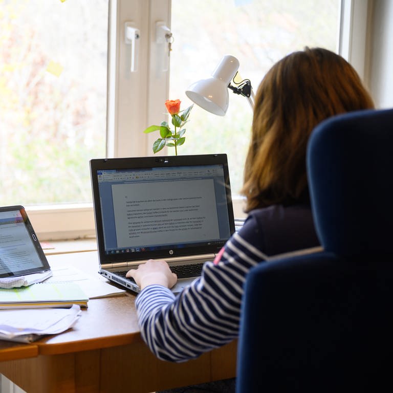 Eine Schülerin sitzt an ihrem Computer und macht Hausaufgaben