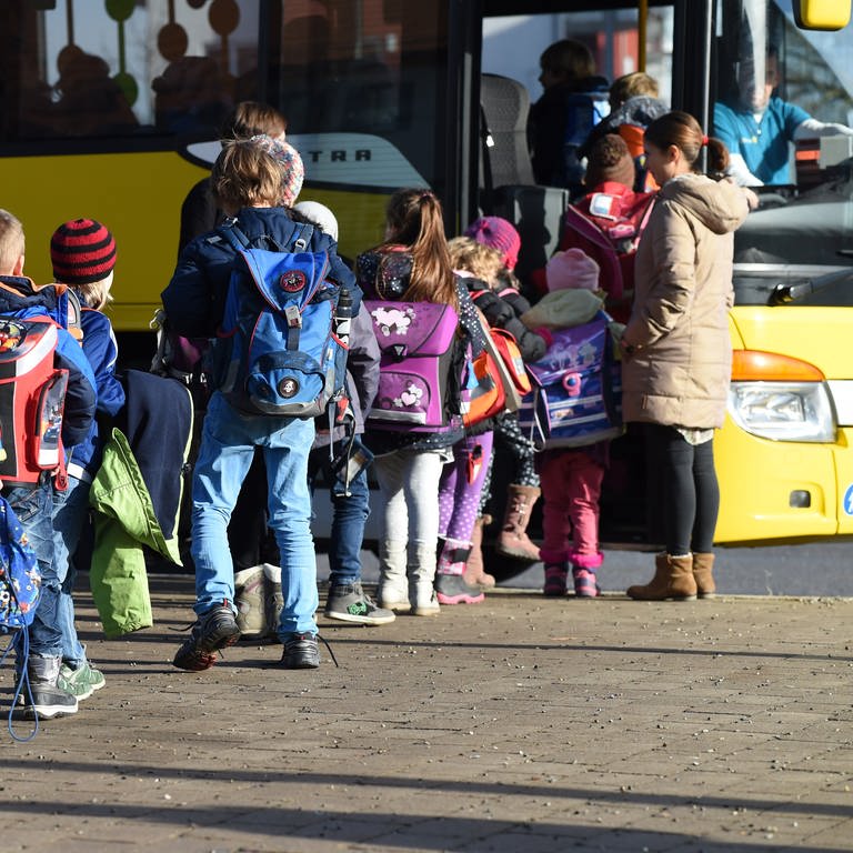 Mehrere Schülerinnen und Schüler steigen in einen Schulbus ein. (Foto: dpa Bildfunk, Picture Alliance)