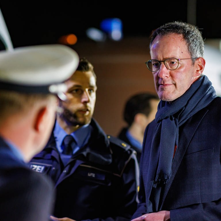 Michael Ebling (r,SPD), Innenminister von Rheinland-Pfalz, bei der Großkontrolle zur Bekämpfung von Geldautomaten-Sprengungen an der A61 im Gespräch mit Polizisten. 