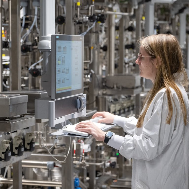 Julia Gueter steht im interdisziplinären Entwicklungszentrums für Biotechnologie des Pharmaunternehmes Boehringer Ingelheim Pharma GmbH & Co. KG in einem Raum mit Zellfermentierern.