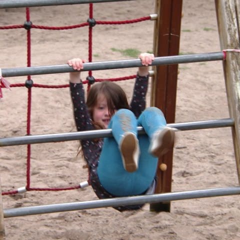 Kind spielt auf Klettergerüst