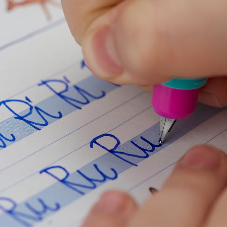 Nahaufnahme von Kinderhand mit Füller bei Schreibübung