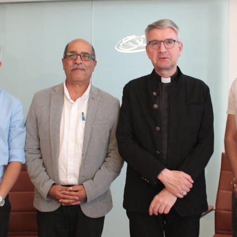Die Iraner Erfan und Milad, der Leiter der Mainzer Hilfsinitiative, Behrouz, Bischof Peter Kohlgraf