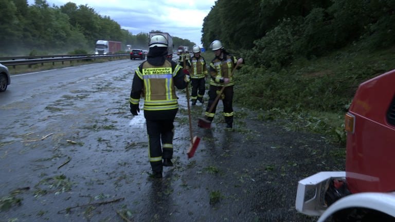 Feuerwehrleute räumen A48 auf, nachdem wegen eines Unwetters Bäume auf die Fahrbahn gefallen sind 