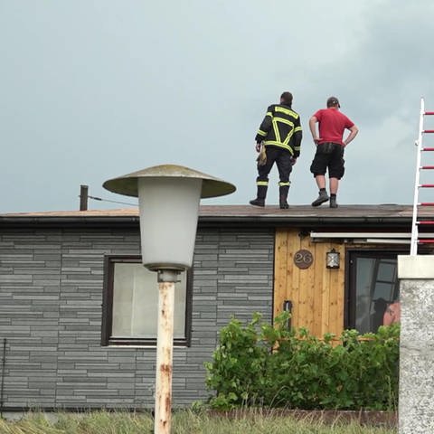 Bauarbeiter auf dem Dach nach Unwetter
