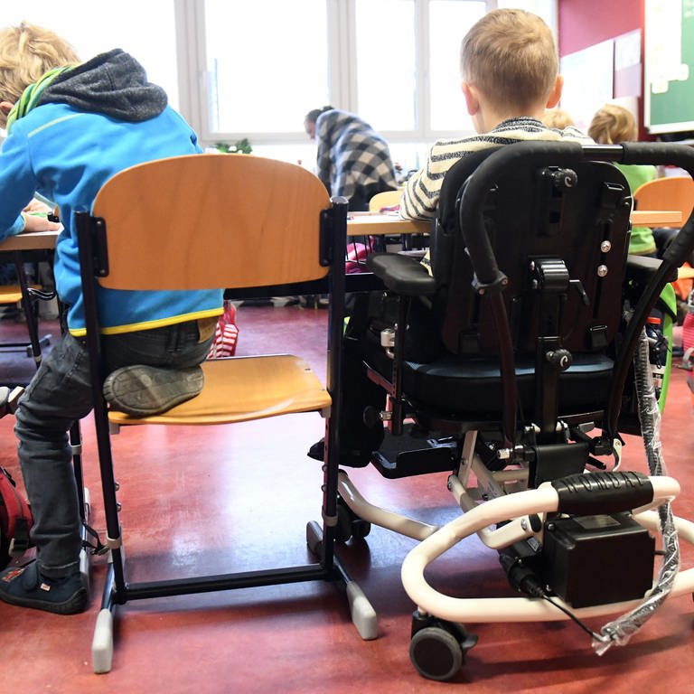 Behindertes und nicht behindertes Kind im Klassenzimmern an einem Tisch
