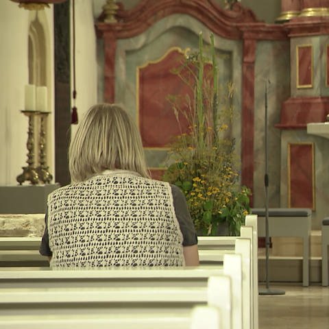 Frau sitzt in einer Kirche