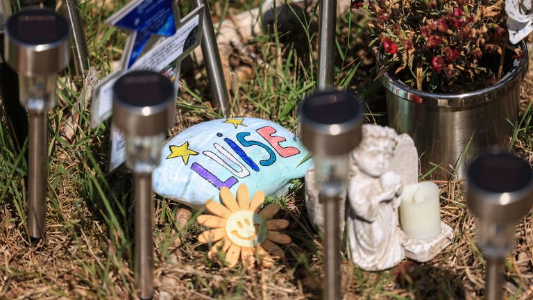 Steine, Blumen und Lichter stehen am Waldrand an der Stelle, an der das Mädchen Luise tot gefunden wurde.  (Foto: dpa Bildfunk, picture alliance/dpa | Oliver Berg)