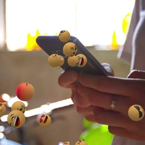 Emojis über einem Smartphone