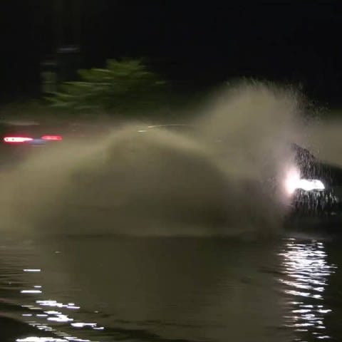 Auto fährt durch Hochwasser
