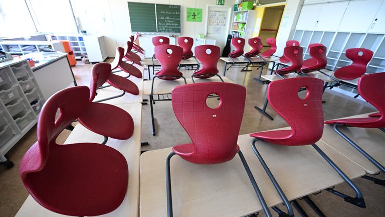 Ein leeres Klassenzimmer mit roten Stühlen