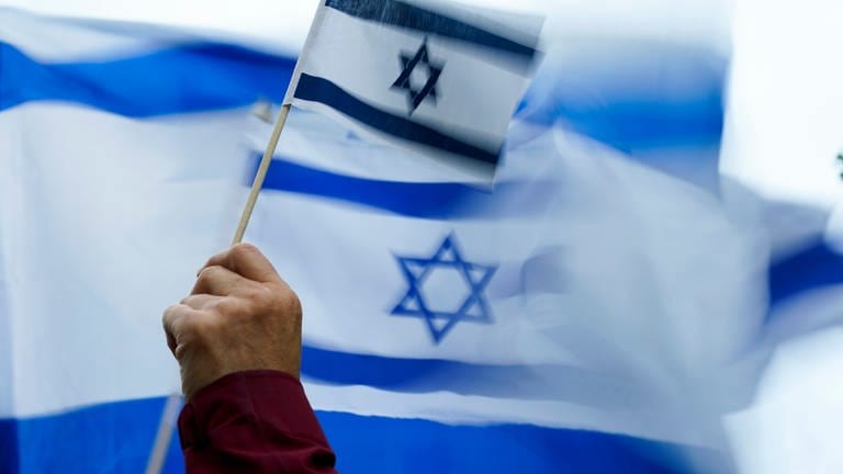 Eine Hand hält eine Flagge Israels