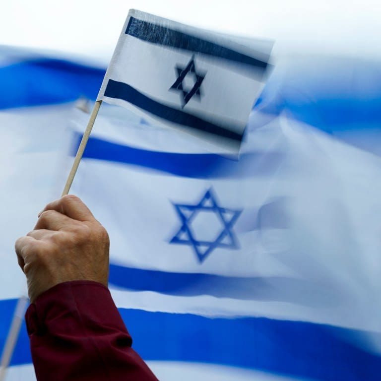 Eine Hand hält eine Flagge Israels