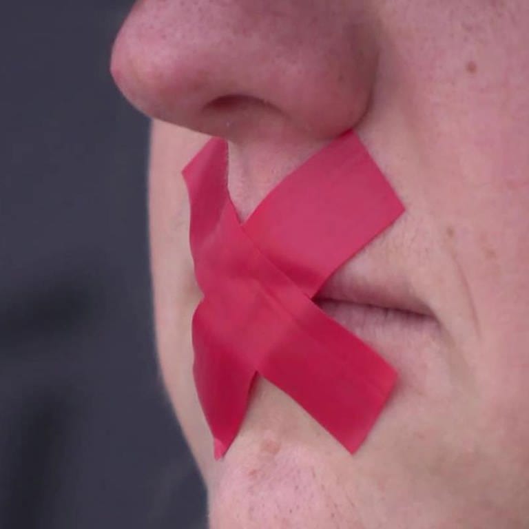 Person mit Klebeband-Kreuz auf Mund (Foto: SWR)