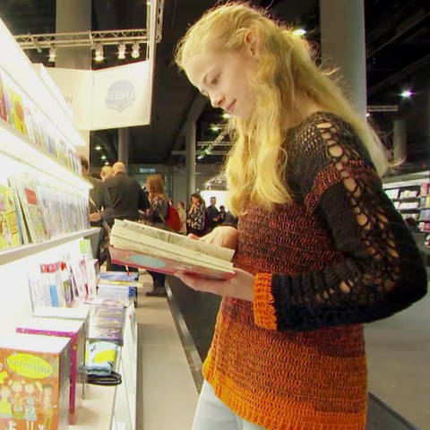 eine junge Lesebegeisterte stöbert in einem Buch