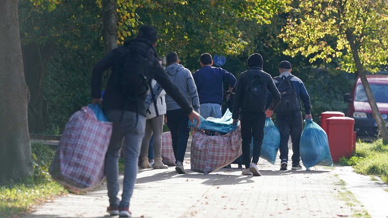 Flüchtlinge aus Syrien gehen mit ihrem Gepäck zu einer Erstaufnahmeeinrichtung 