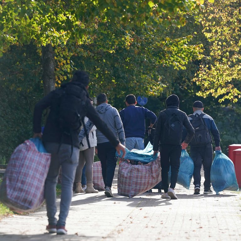 Flüchtlinge aus Syrien gehen mit ihrem Gepäck zu einer Erstaufnahmeeinrichtung 