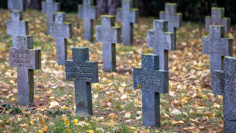 Kreuze markieren Gräber von Gefallenen auf einem Friedhof.