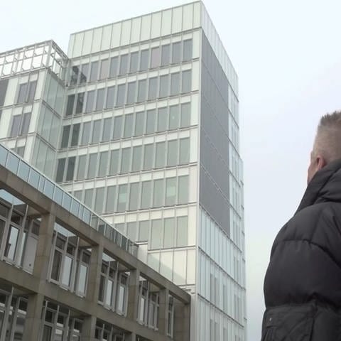Mann schaut zu einem Gebäude hoch