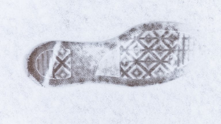 Ein Abdruck einer Schuhsohle ist im Schnee zu sehen.
