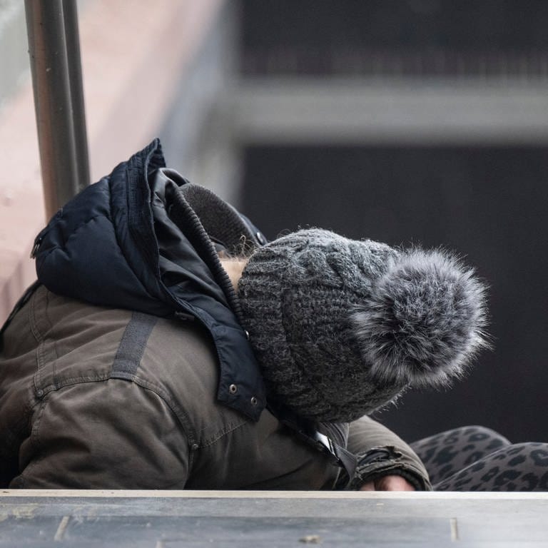 Ein Obdachloser schläft auf einer Treppe des Hauptbahnhofs in Frankfurt.