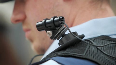 Ein Polizist trägt eine mobile Miniatur-Videokamera (Bodycam) auf seiner Schulter. (Foto: dpa Bildfunk, Picture Alliance)