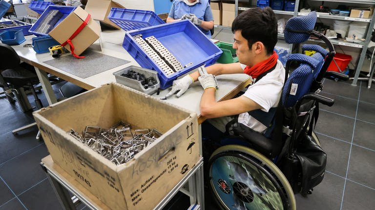 Ein Mitarbeiter arbeitet in einer Behindertenwerkstatt.