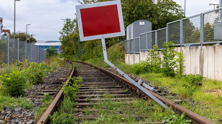 Eine stillgelegte Bahnstrecke ist mit einem roten Schild als gesperrt gekennzeichnet 