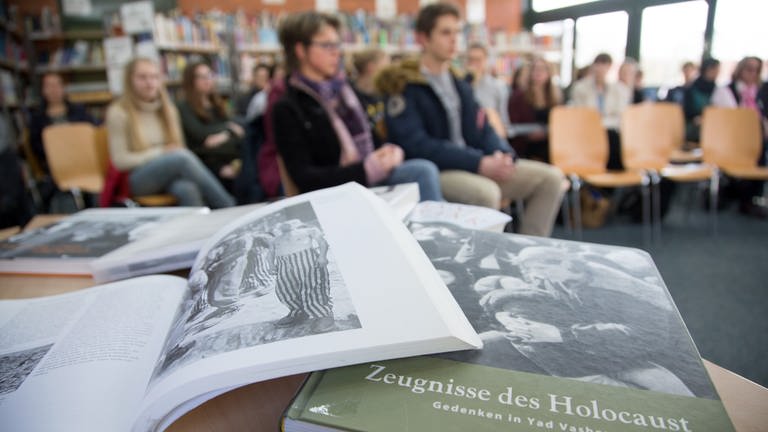 Bücher über den Holocaust als Lehrmaterial liegen auf dem Pult in einer Schule