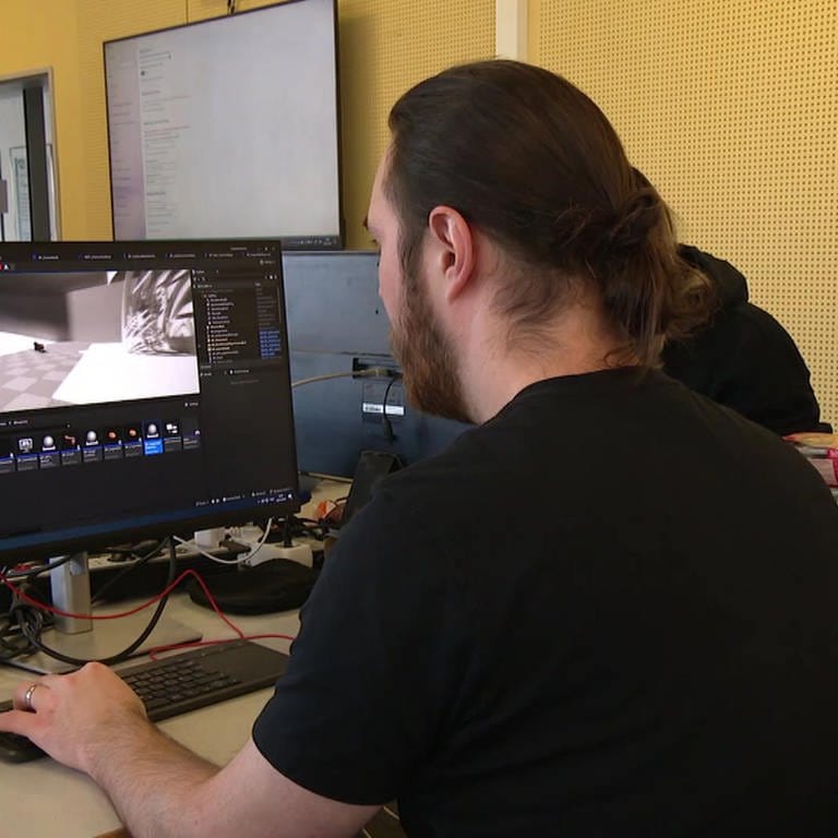 Spieleprogrammierer vor einem Monitor