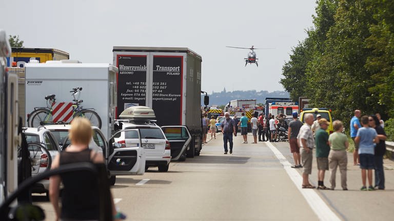 Autofahrer stehen am auf der Autobahn A61 bei Kruft (Rheinland-Pfalz) nach einem LKW-Unfall im Stau