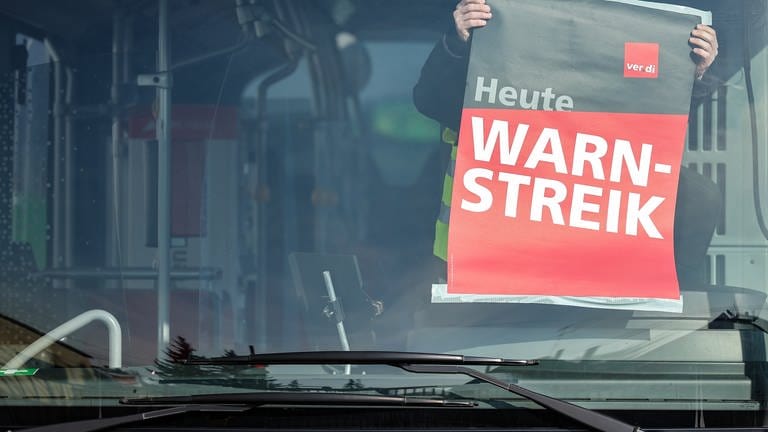 Warnstreik-Schild wird innen an Bus geklebt. (Foto: dpa Bildfunk, picture alliance/dpa | Jan Woitas)