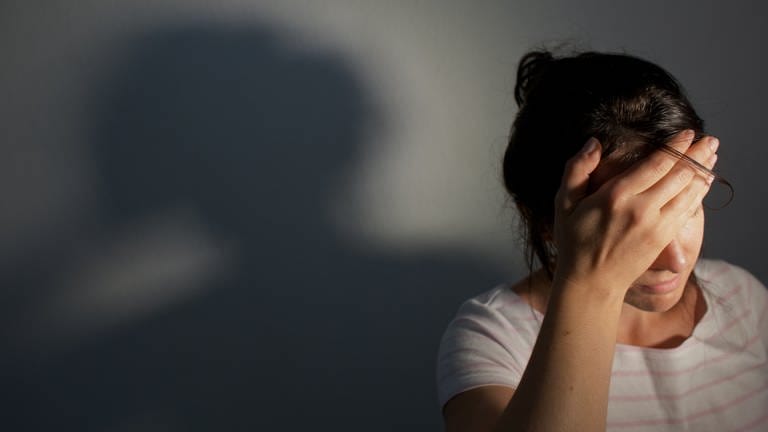 Eine Frau hält wegen Kopfschmerzen ihre Hand an ihren Kopf. (Foto: picture-alliance / Reportdienste, Picture Alliance)