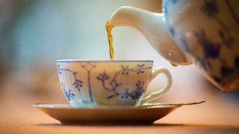 Tee wird in eine Tasse eingeschenkt.  (Foto: dpa Bildfunk, Picture Alliance)