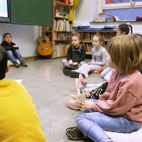 Kinder sitzen im Kreis in der Schule