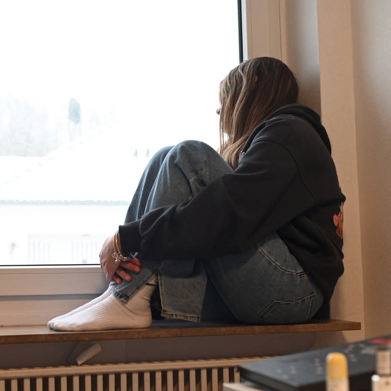 Deprimiert sitzt ein jugendliches Mädchen in ihrem Zimmer. Immer mehr Mädchen unter 14 Jahren melden sich beim Mainzer Frauennotruf.
