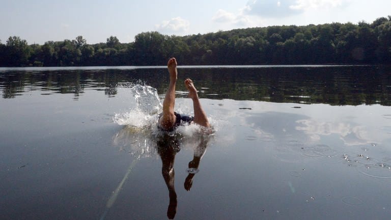 Ein Mann springt in einen Badesee. Die Qualität der Badeseen in Rheinland Pfalz kann man jetzt online nachschauen.