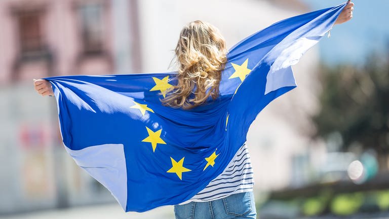 Junge Frau trägt eine Europaflagge