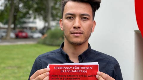 Ein junger Afghane hält einen Flyer in die Kamera. (Foto: SWR, SWR)