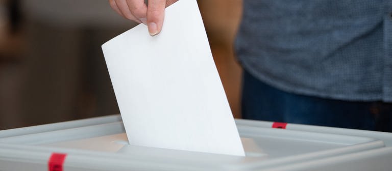 Ein Mann wirft einen Stimmzettel in eine Urne. (Foto: picture-alliance / Reportdienste, Sebastian Kahnert)